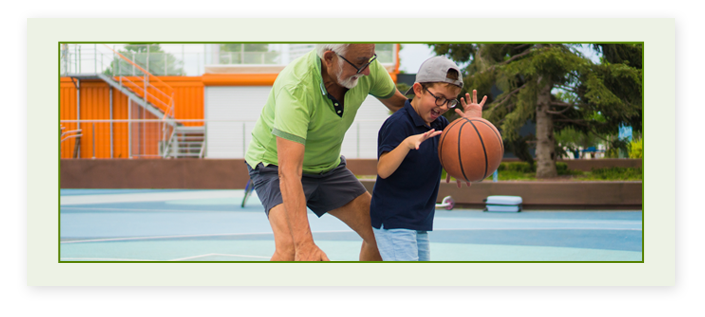 A grandpa and grandson playing basketball outside