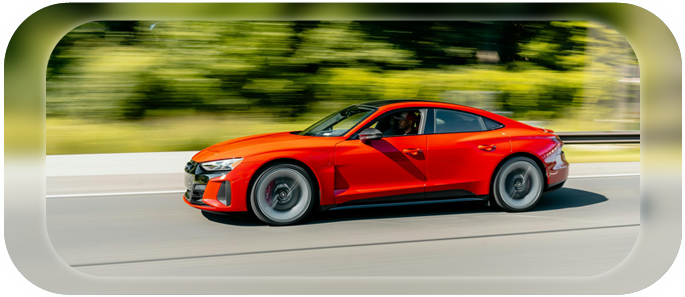 A red car driving down the road