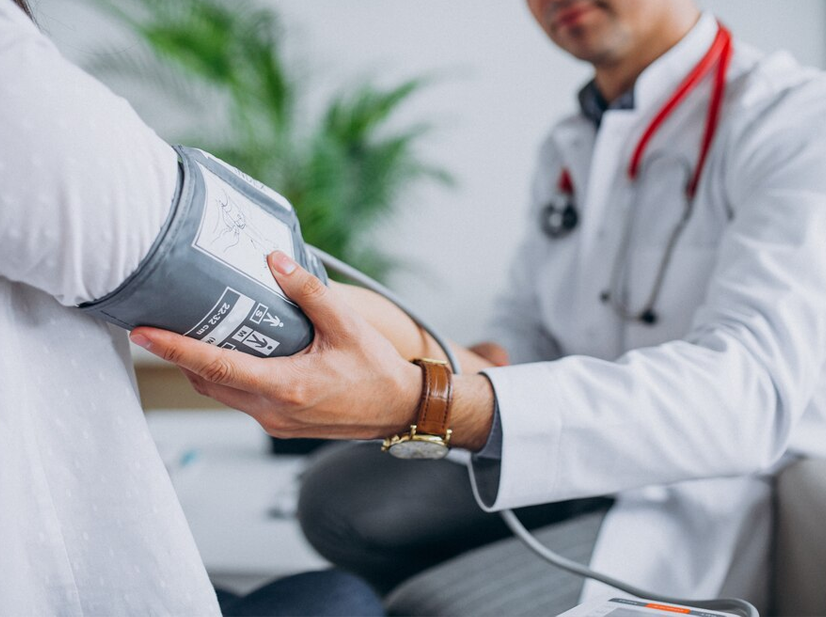 Doctor measuring patient blood pressure with cuff during medical checkup