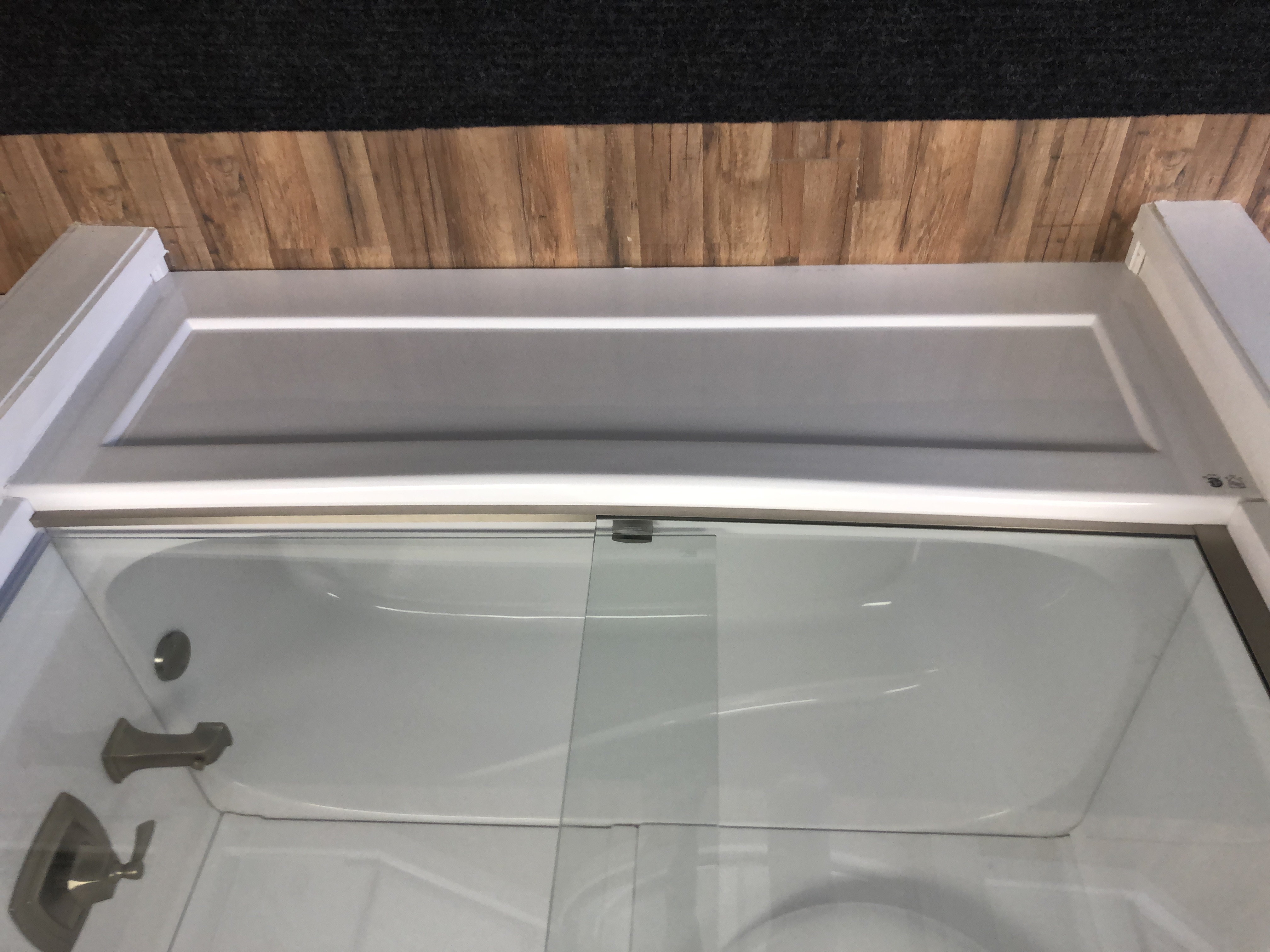 Modern bathroom interior with freestanding bathtub, glass shower enclosure, wooden vanity with double sinks, large window, and potted plants.