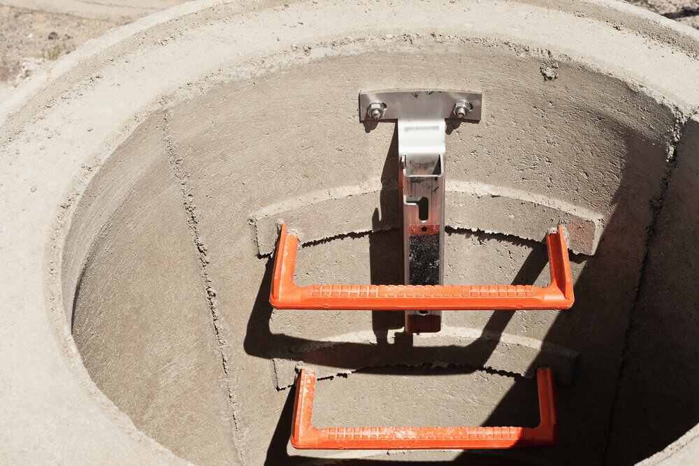 A newly built manhole with steps leading down.