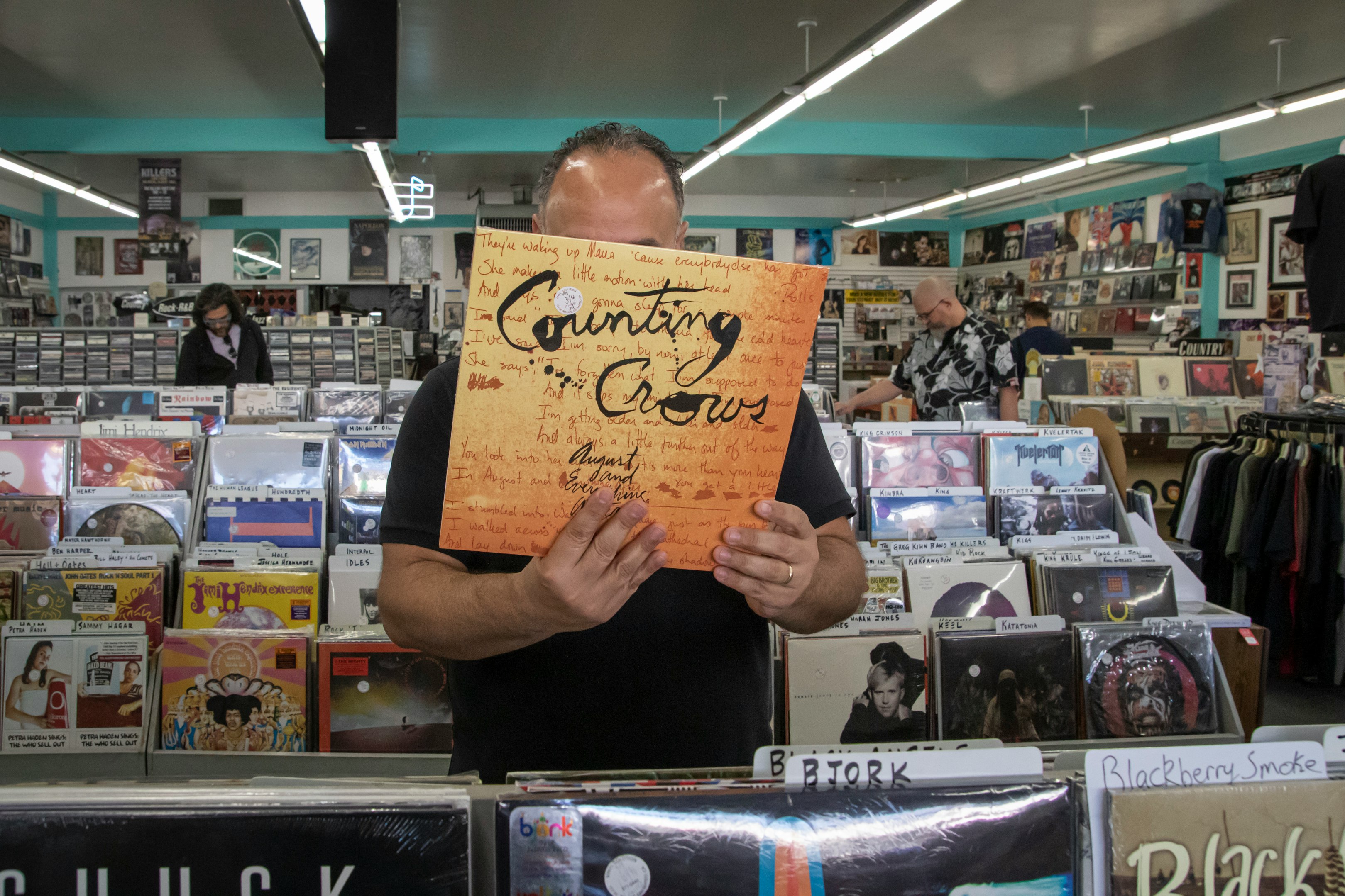 a man holding up a sign in a store a man holding up a sign in a store