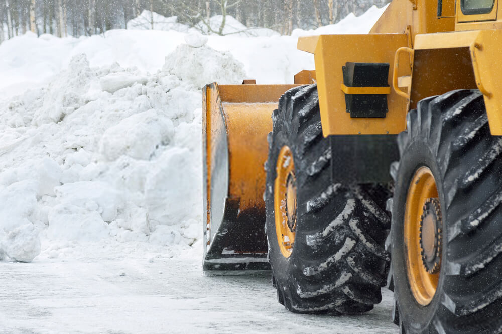 Large piles of snow being cleared by heavy machinery