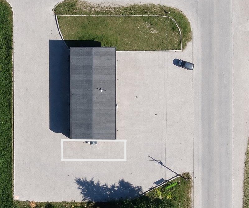 Modern car wash facility with a white sedan in the wash bay and employee at computer terminal.