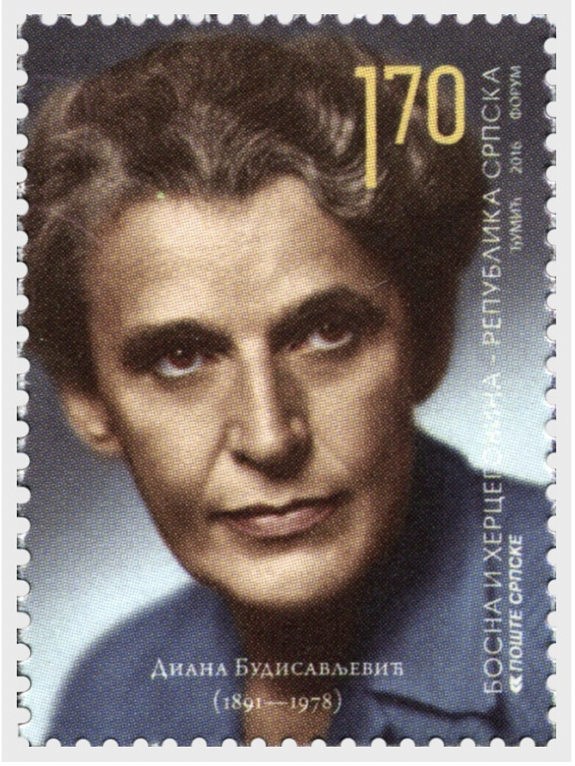 Woman with wavy hair gazing out an old window, wearing an olive green jacket.
