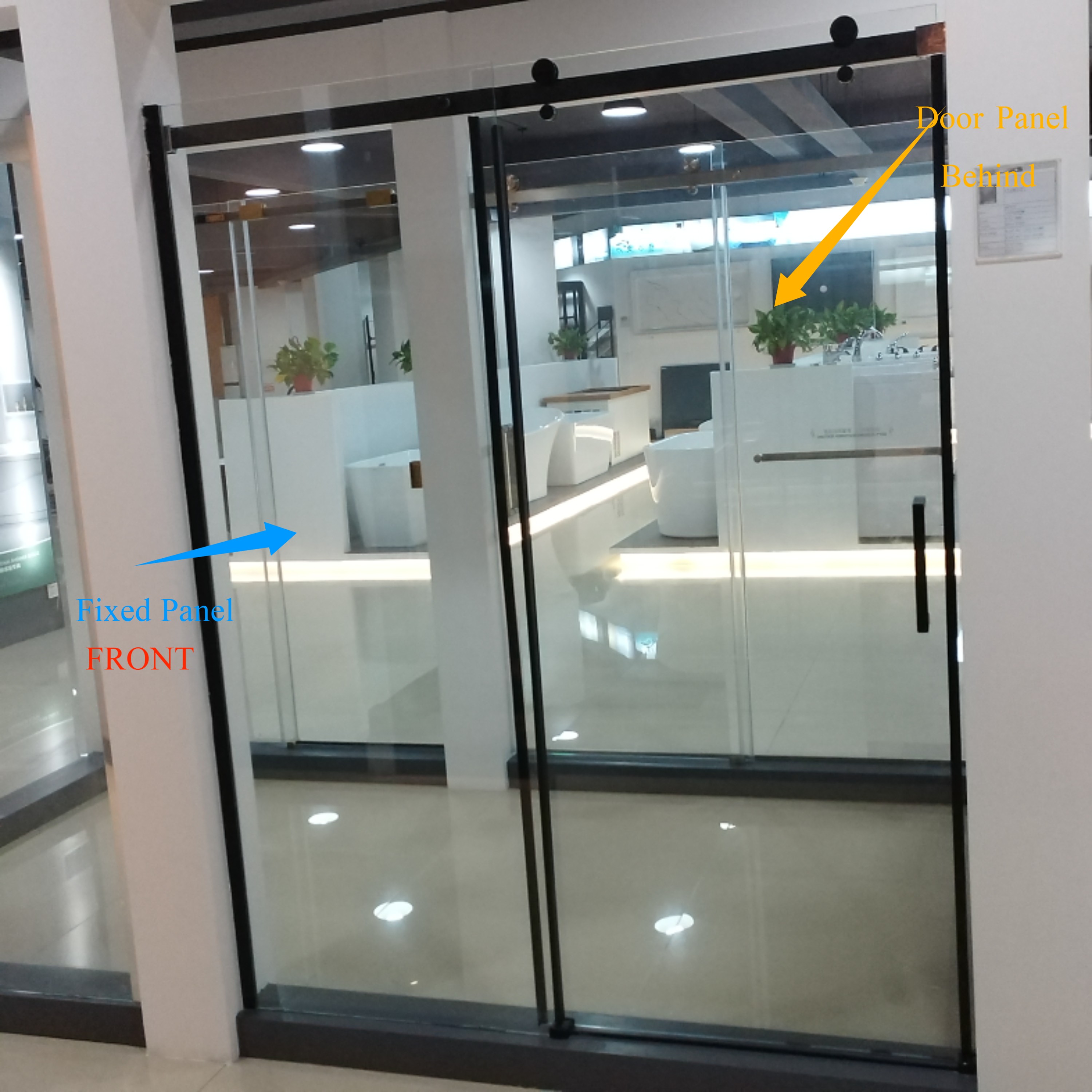 Modern bathroom with large bathtub, glass shower, wood vanity, and greenery by the window.