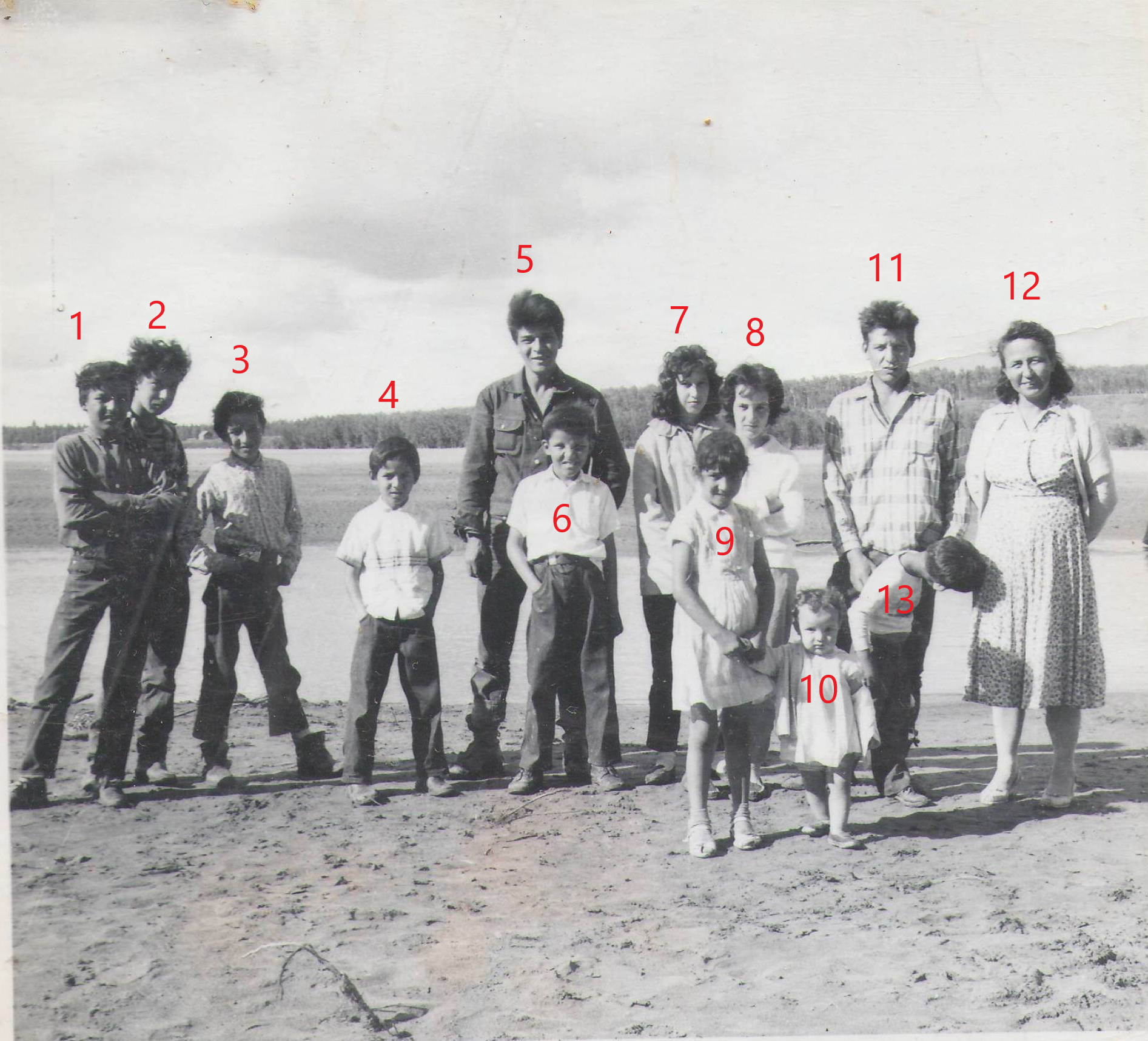 This photo is labelled as "Cousins Laure Clarke Christians family at Carcajou". Which is great start in determining who is who - but we still need your help to that end! The second image has numbers please put the number beside the name of the people you recognize!

-EDIT-

1 Boxer 2 Jack 3 Skinny 4Neil 5Henry 6 Wally 7 patricia 8 Priscilla 9 Doris 10 Barb 11 Dad 12 mom 13 Russell
2019.24.448 / Lizotte, Maria