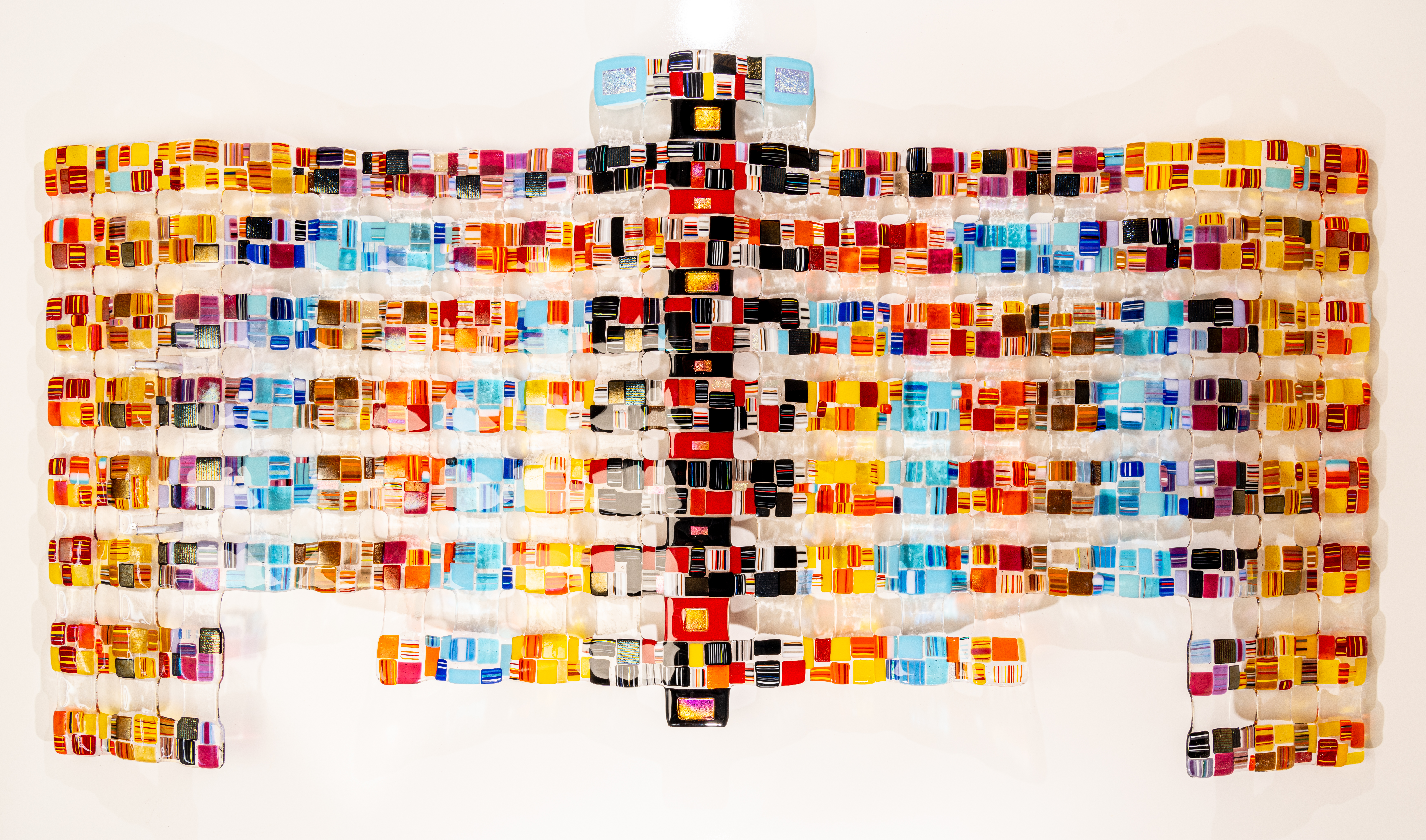 Three vintage cars in a warehouse: a lavender car in the foreground, with green and turquoise cars behind.