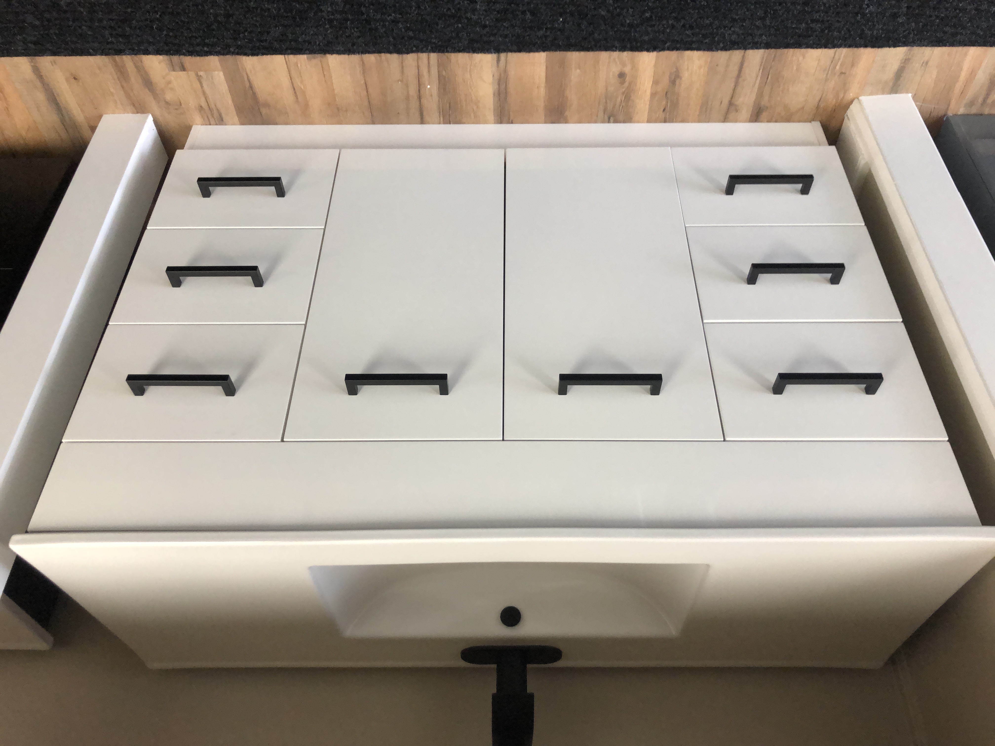 Modern bathroom with white bathtub, glass shower enclosure, floating vanity, large mirror, and green plants, featuring natural light and marble flooring.
