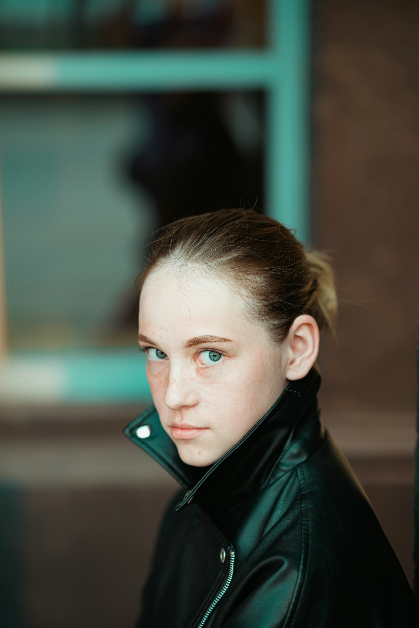 a woman in a black leather jacket looking at the camera