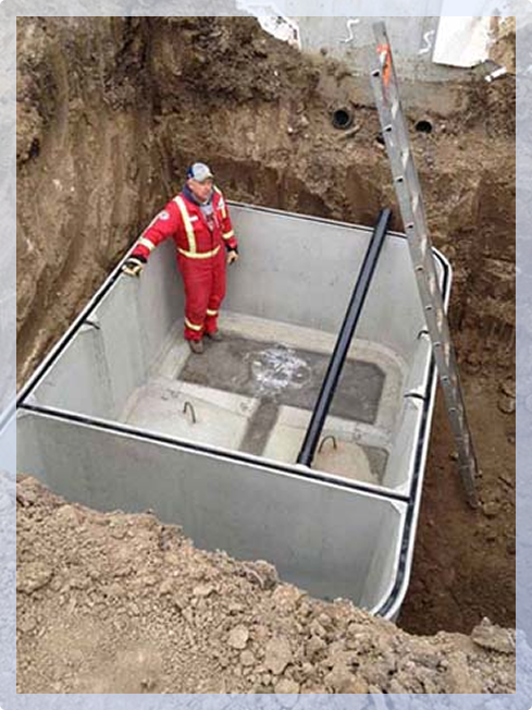 Worker standing in septic chamber installation