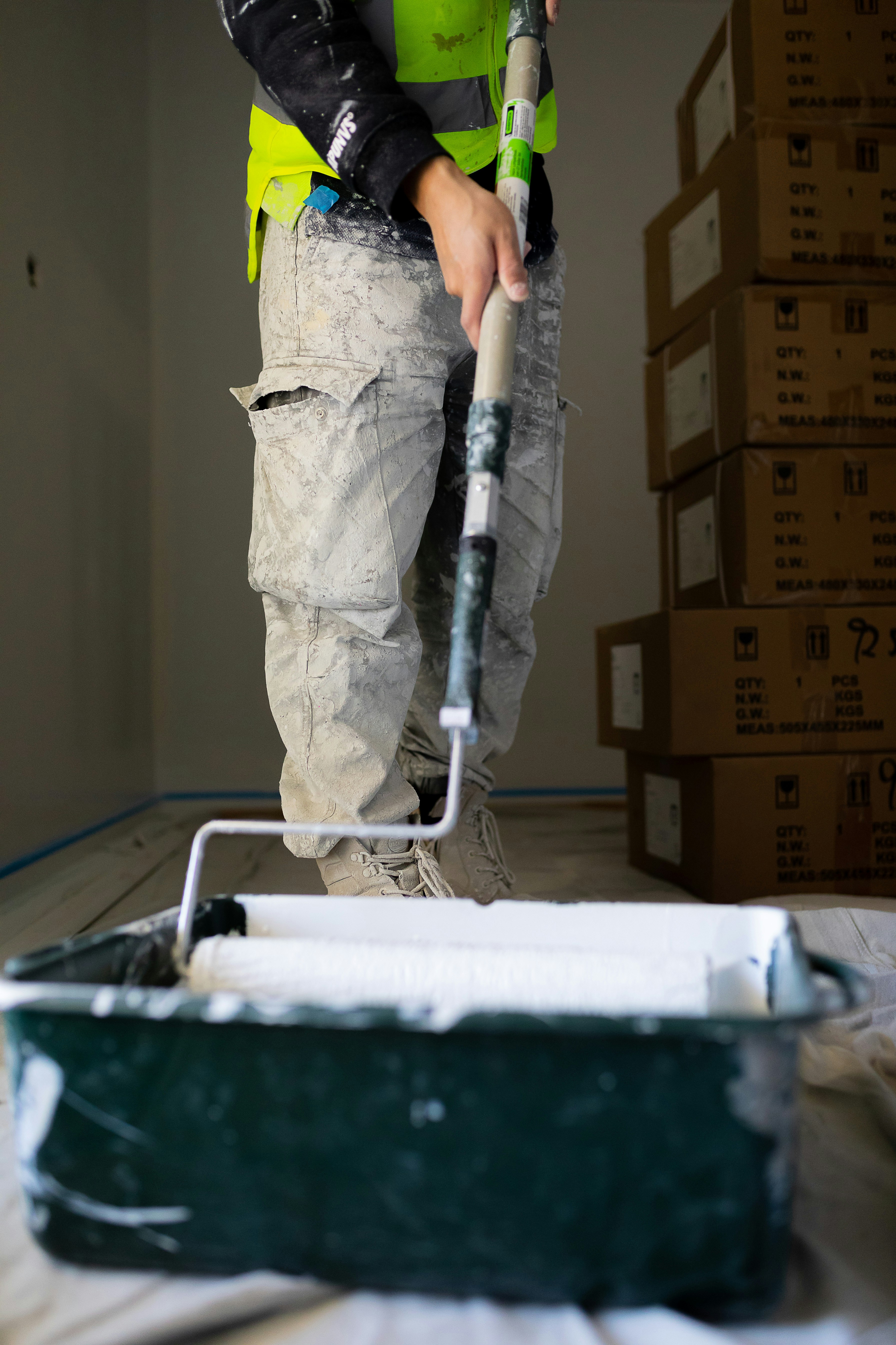 Professional home repair contractors with tool belts standing in a renovated room with toolbox and supplies