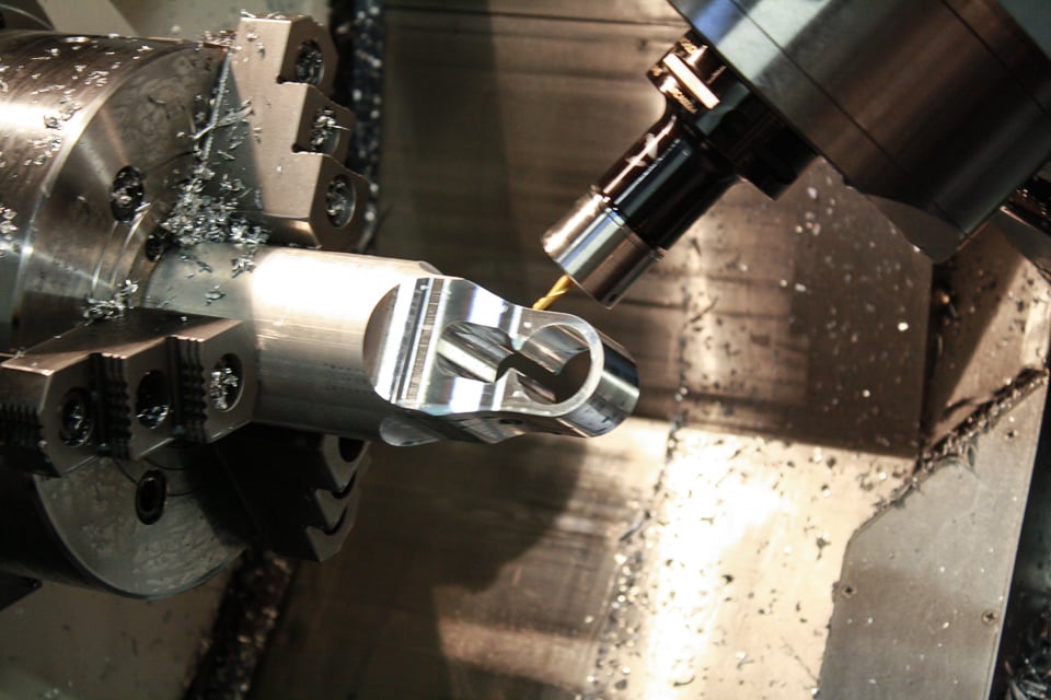 Close-up view of a precision CNC machining process with a metal cutting tool in action, surrounded by intricate metal components on a manufacturing assembly line.