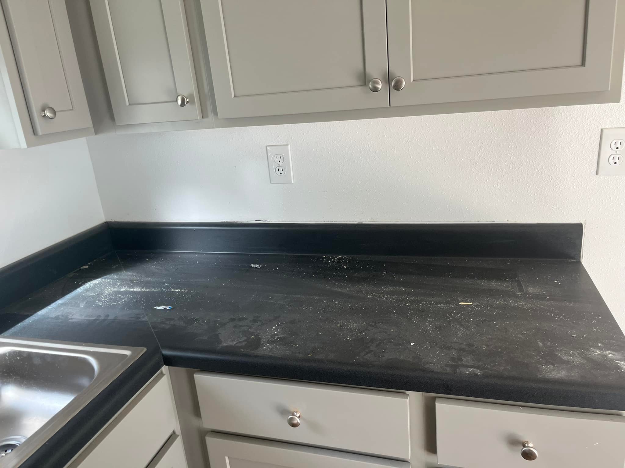 Kitchen countertop in active post-renovation condition with construction dust, residue, and surfaces awaiting recovery preparation