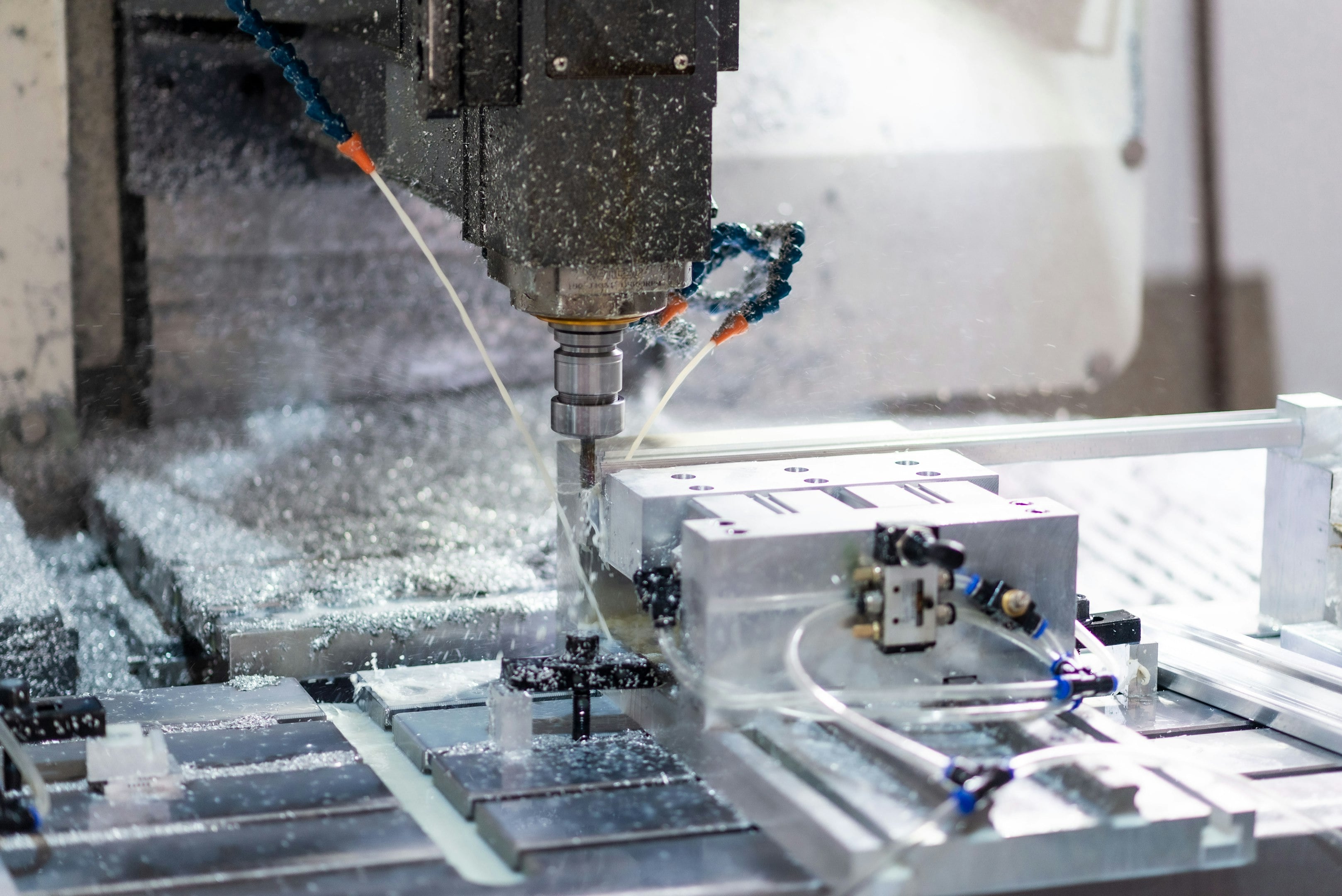 Close-up of a CNC machine milling a metal component in a workshop setting.