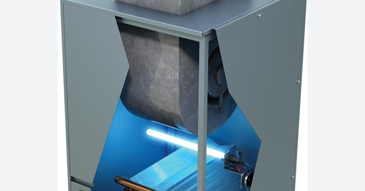 Technician in uniform adjusting control panel of a heating and cooling system with Golden Ears branding.