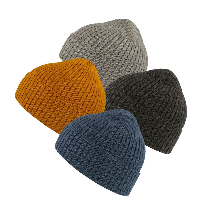 a woman sitting on the side of a road next to a red bag