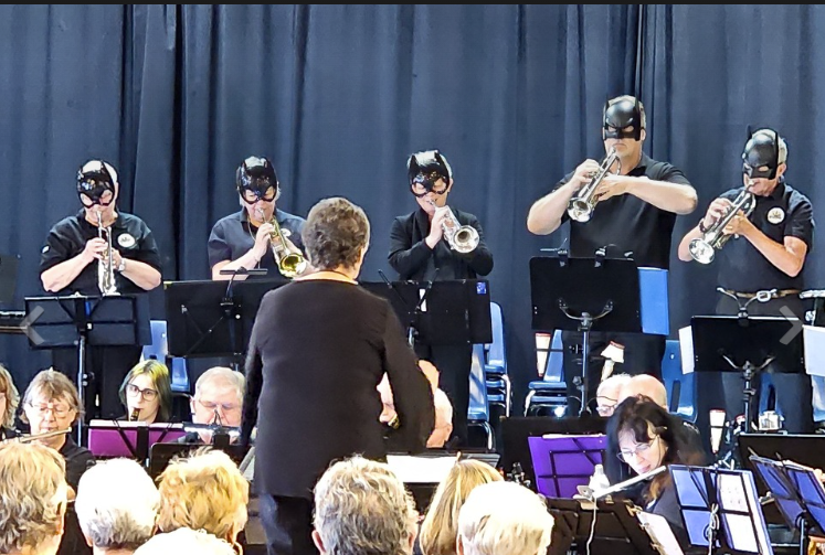 April 2024 Concert at Wilmot Creek.  Trumpet section dressed in Batman masks playing theme from the 1960's show Batman. 

