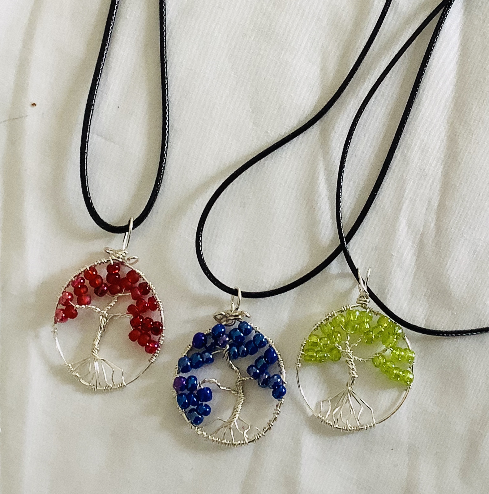 Trees of Life Pendants has special meaning “symbol of a fresh start in life”.  These pendants are hand wired in a myriad of colors, including birthstone colors, family tree colors or any other color of ones choice.   $25.00