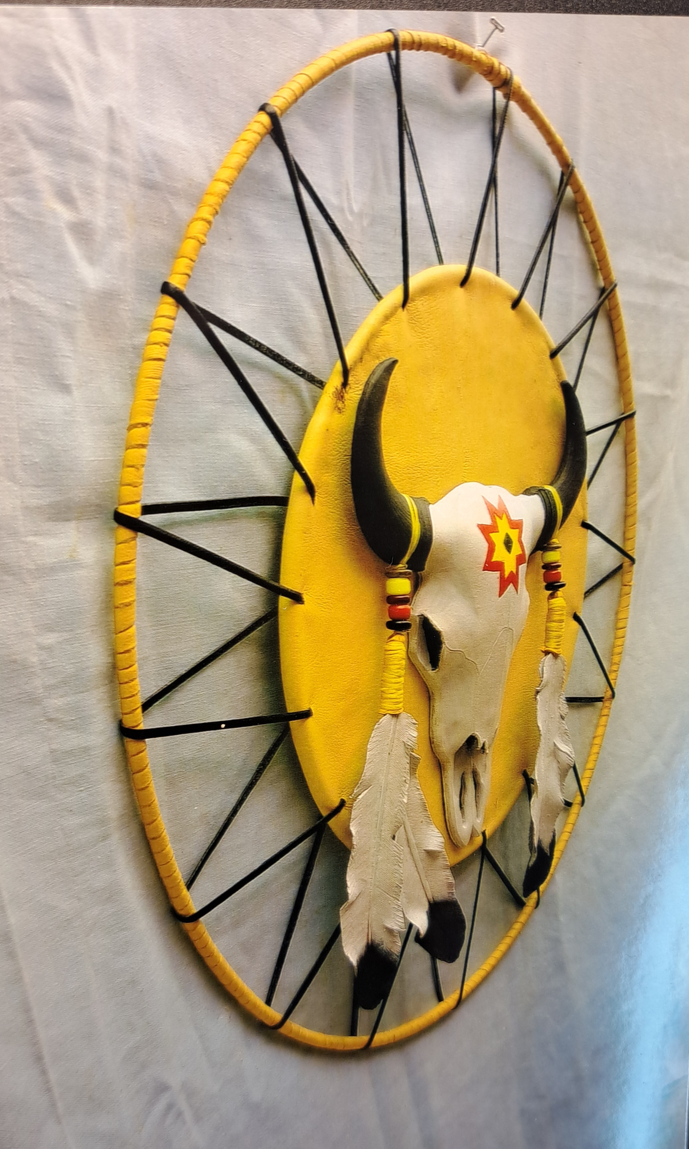 A custom yellow piece of wall art detailing a bull skeleton and fathers