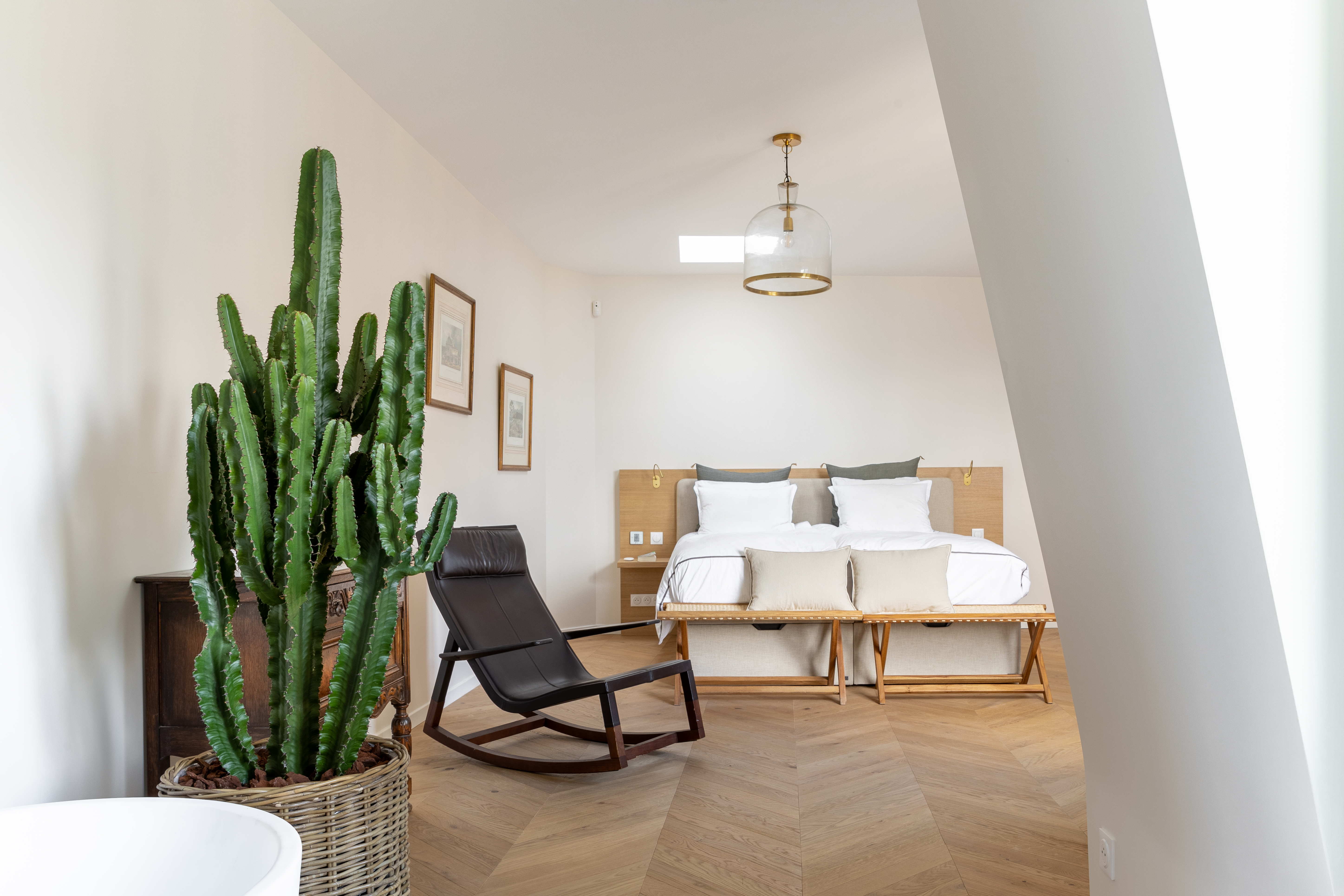 Salon moderne et lumineux avec canapé beige, table basse en bois, grandes fenêtres et décor minimaliste.