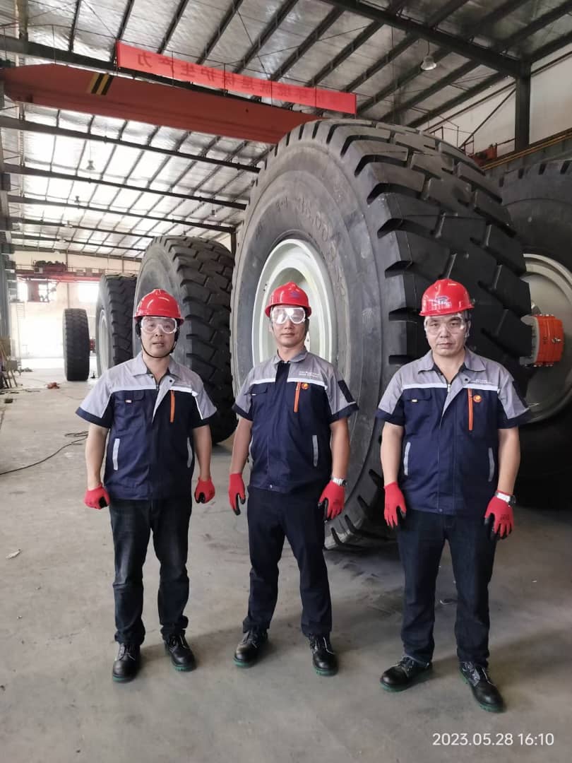 Professional businessman in a modern office, smiling and holding a pen while sitting at a desk with documents and office supplies.