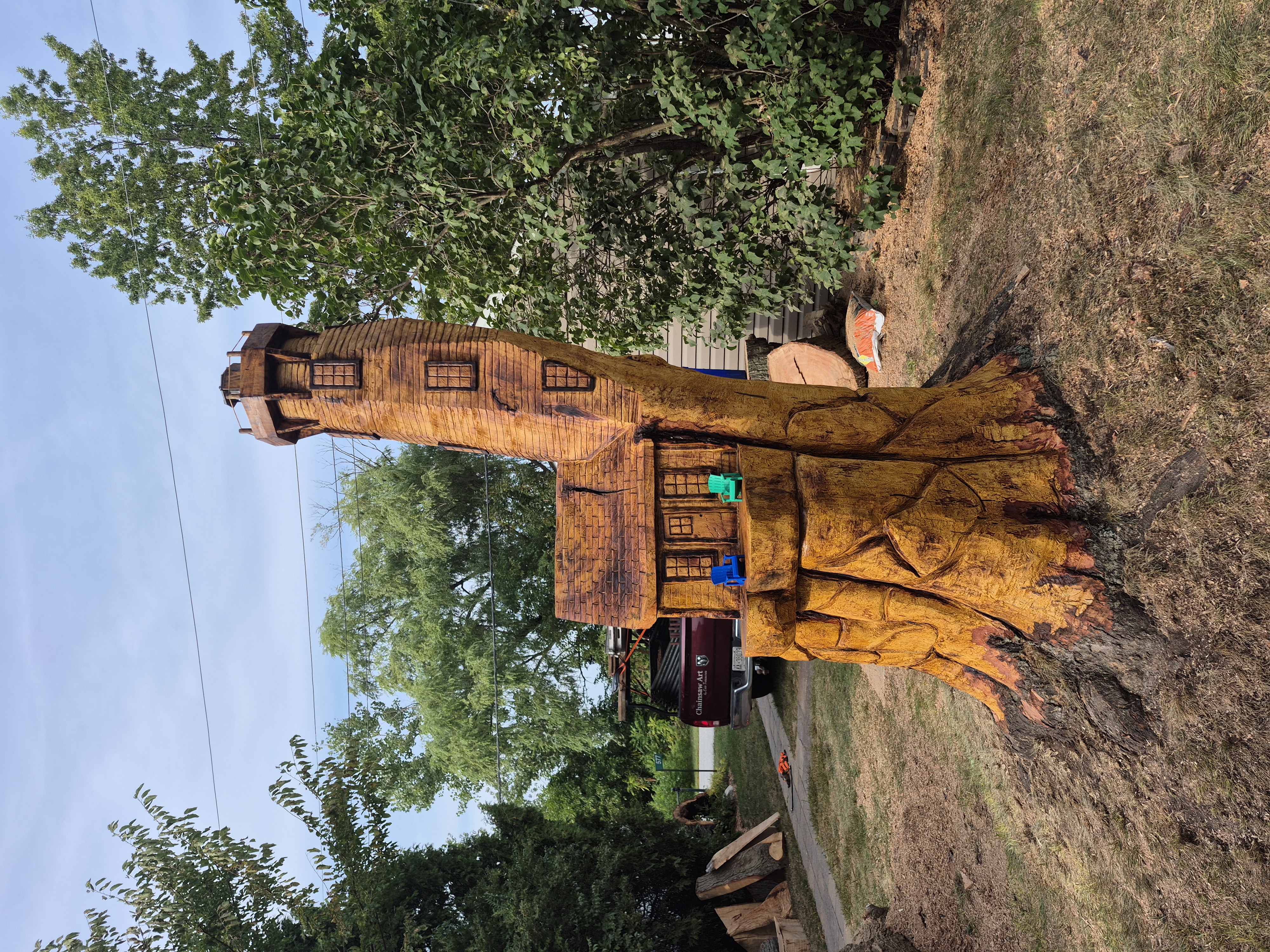 Chainsaw wood carvers creating detailed animal sculptures from tree stumps in a backyard garden