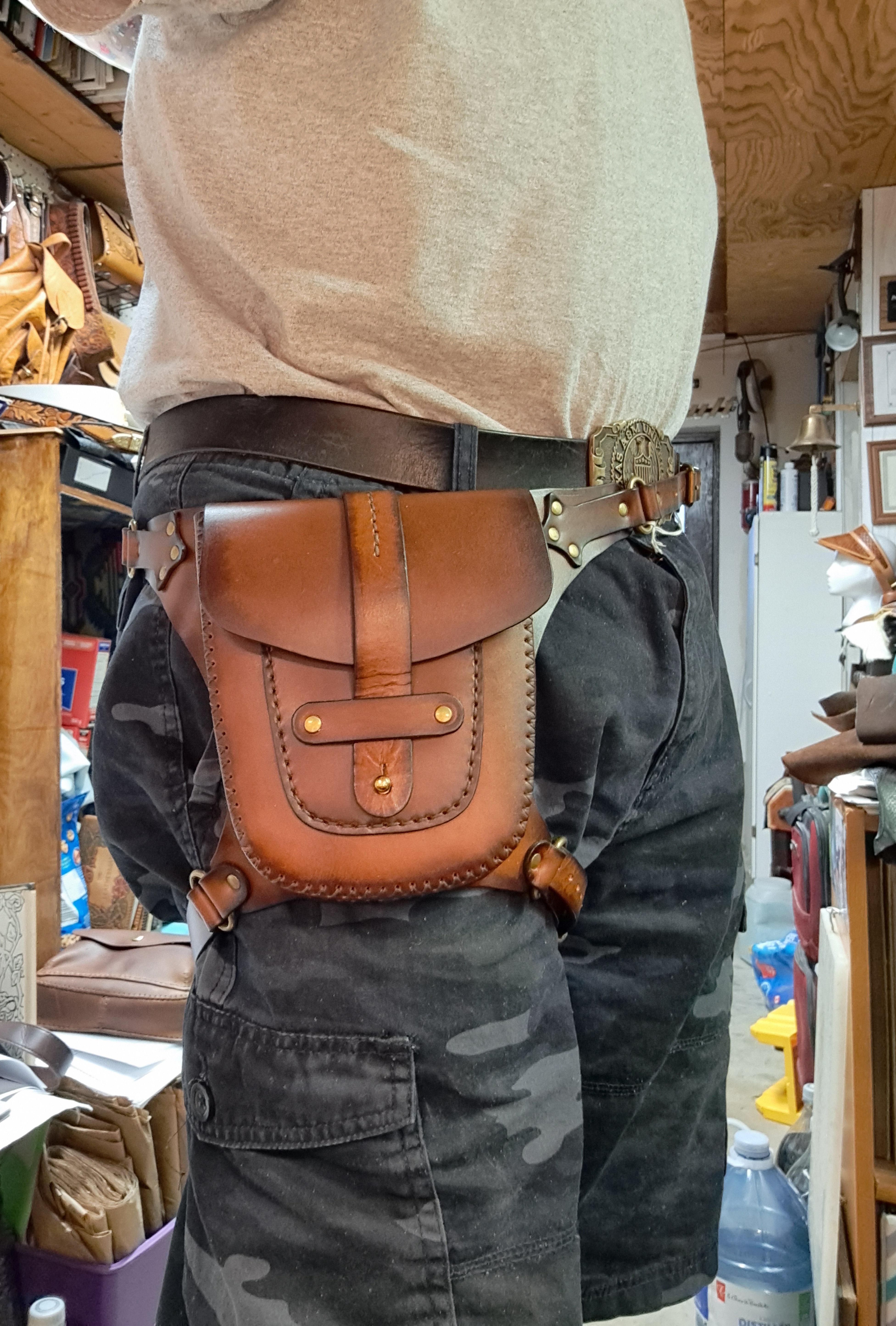 A man wearing a brown leather pouch strapped to his leg