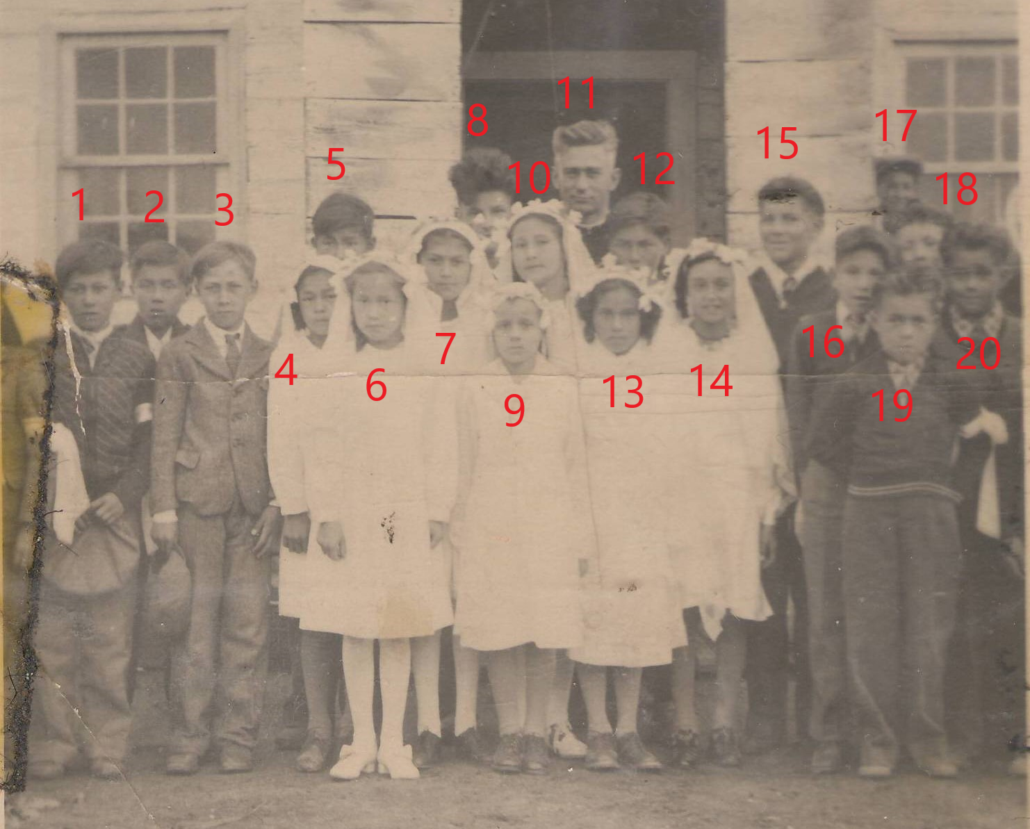 This a confirmation class at the St Louis Church in Buttertown. We have a list of people in the photo - but are struggling to connect the names to the faces. The names listed are:
Back Row: L-R Isaac Paul, Ami Lambert, Ralph Lizotte, Arthur Lizotte, 2 unknown boys
Middle Row: L-R Frieda Lizotte, Jenny Lizotte, Pearl Lizotte, Shirley Lizotte
Front Row: George Lizotte daughters: Unknown, Moira Lambert, Hilda Lambert
If you could help us connect the names with the numbers we have added to the photo that would be greatly appreciated!
-EDIT-
1) Lornie Paul, 2) Norman Lambert, 3) Ami Lambert, 4) Frieda Lizotte, 5) Ralph Lizotte, 6) Justine Lizotte, 7) Jenny Lizotte, 8.) Arthur Lizotte, 9) Moira Lambert 10) Vyrl Lizotte, 11) Father John, 12) Philip Lambert? 13) Hilda Lambert, 14) Shirley Lambert 15) Wilbert Lizotte, 16) Punch Lambert, 17) George Lizotte, 18) Elaire Lizotte, 19) Ernest Lizotte, 20) Howard Lizotte.