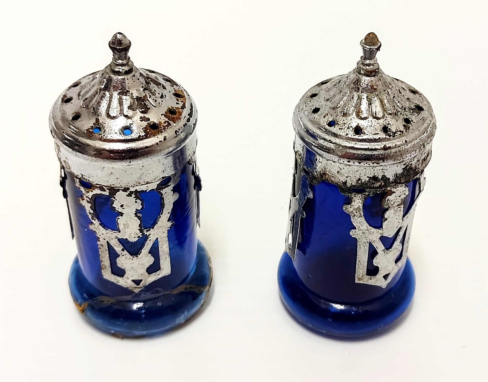 These are salt and pepper shakers from the DA Thomas steam paddler wheel boat. The ship is noted as having "White linen and the finest Silver" as well as electricity and hot / cold running water in the staterooms (Where go the boats pg. 14). The ornate details and cobalt blue glass of these shakers would have added to the luxurious atmosphere - though as far as we can tell there is no indication as to which one is salt and which is pepper!
2002.226.61 / Campbell, Jean