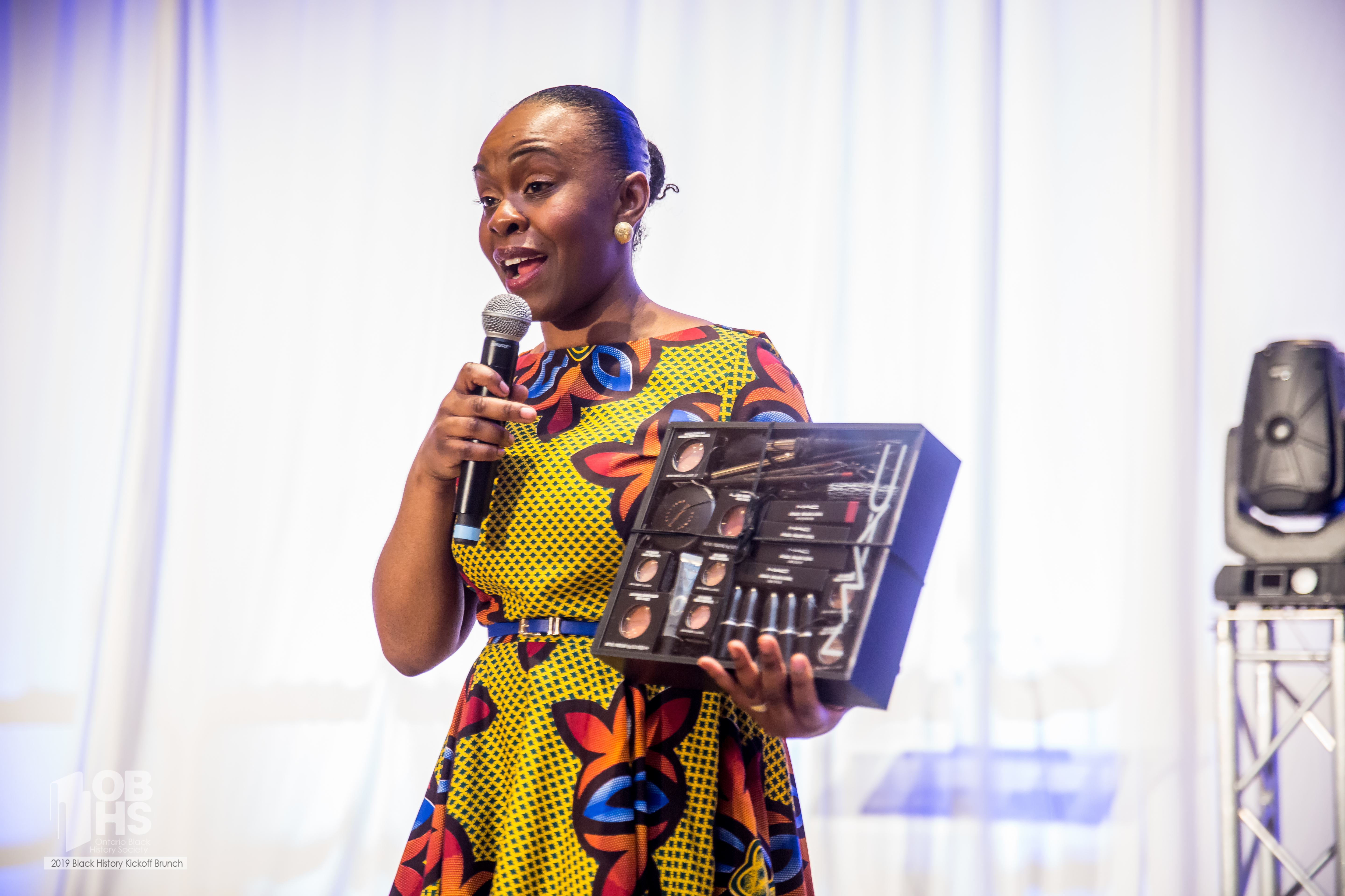 Host Emily Mills presents the MAC Cosmetics door prize! - photo by www.sayhilondon.com
