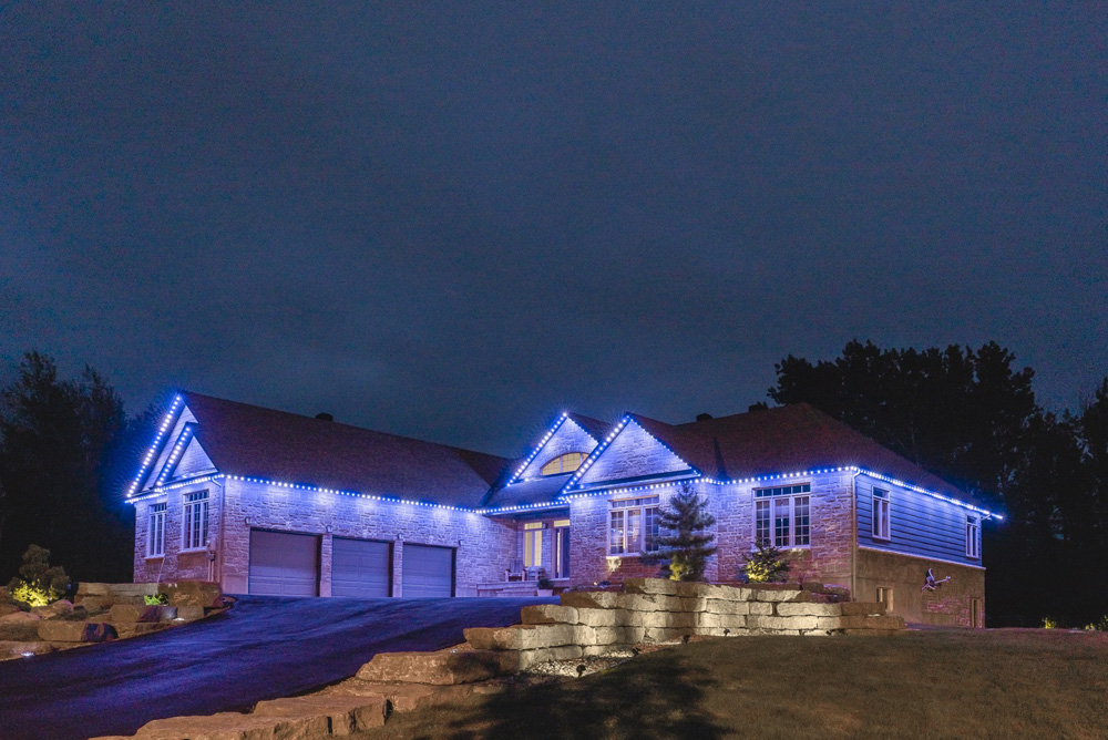 House lit in blue and white in the evening.