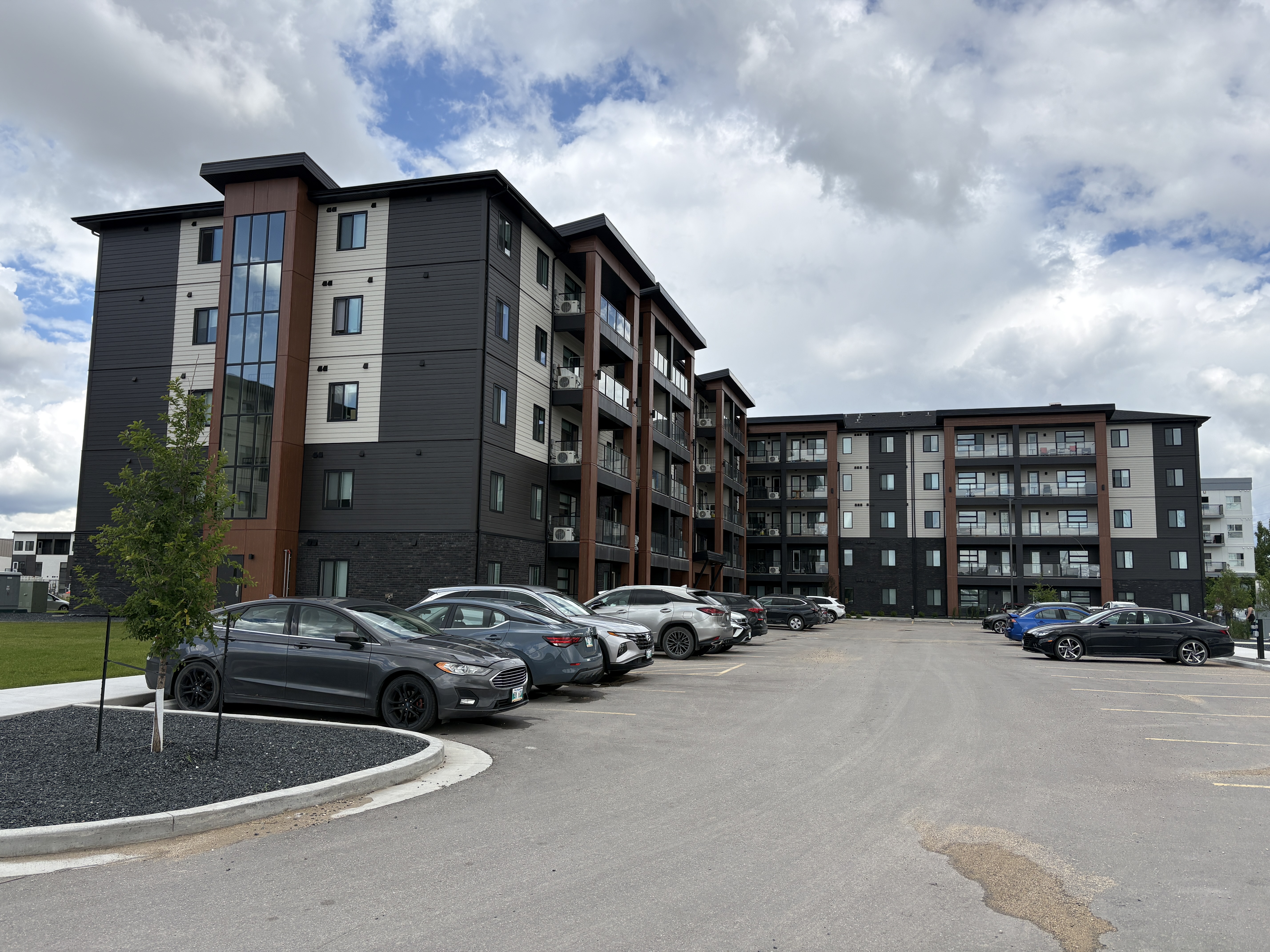 Construction workers painting and finishing exterior of modern commercial building with scaffolding and large glass windows Construction workers painting and finishing exterior of modern commercial building with scaffolding and large glass windows
