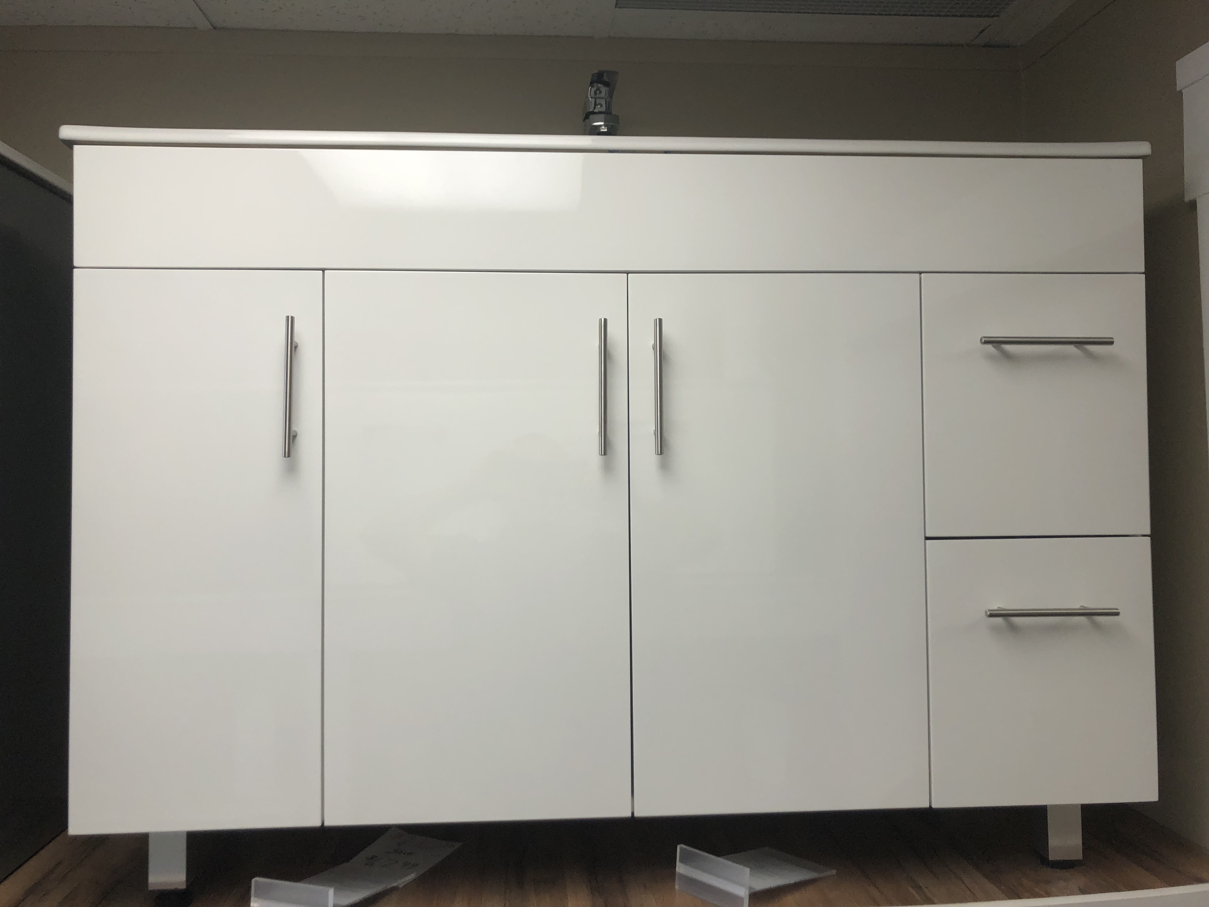 Modern bathroom with sleek vanity, round bathtub, large mirror, plants, and natural lighting.