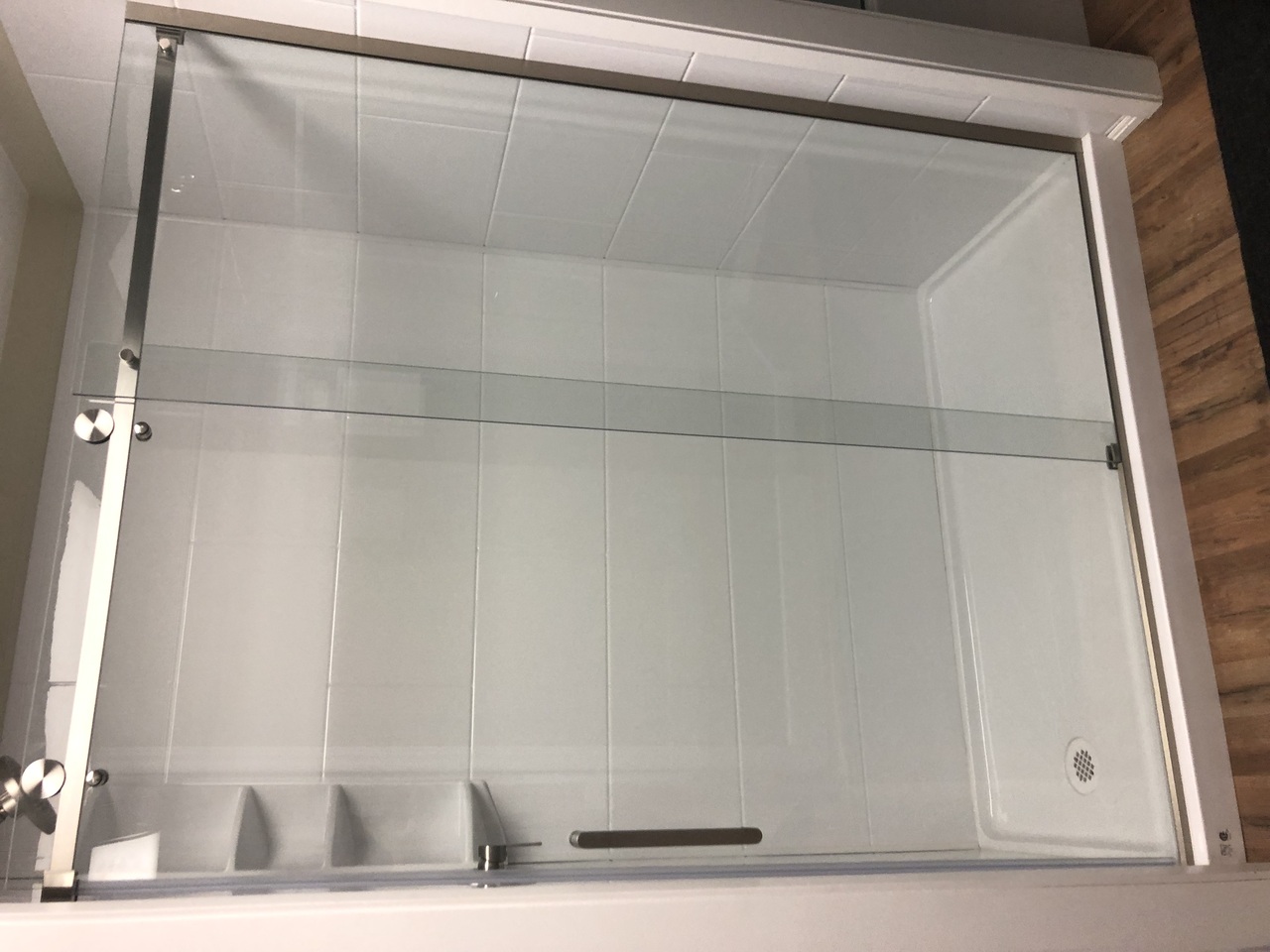 Modern minimalist bathroom with walk-in shower, floating vanity, large mirror, and potted plants. Modern minimalist bathroom with walk-in shower, floating vanity, large mirror, and potted plants.