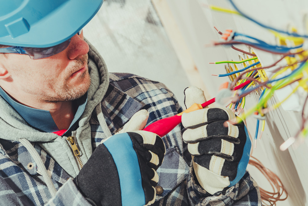 Man in hardhat installing wires.