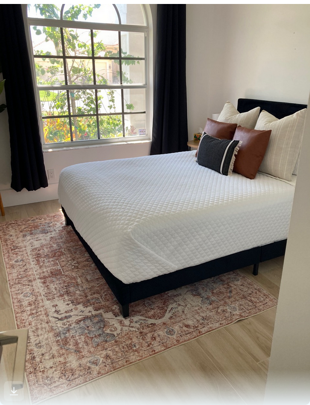 Sunlit Bedroom with Arched Window and Fresh White Bedding