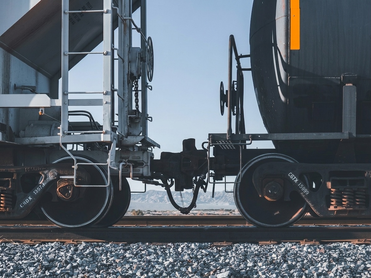 Railway maintenance worker inspecting silver locomotive 819 inside modern train depot