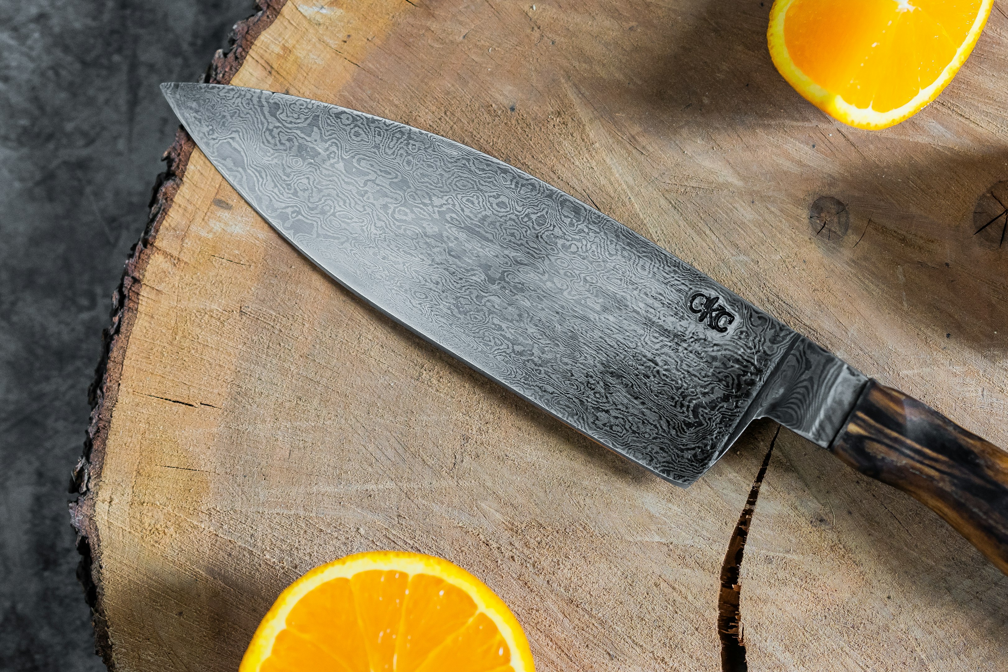 fruit d'orange tranchée à côté d'un couteau en acier inoxydable
