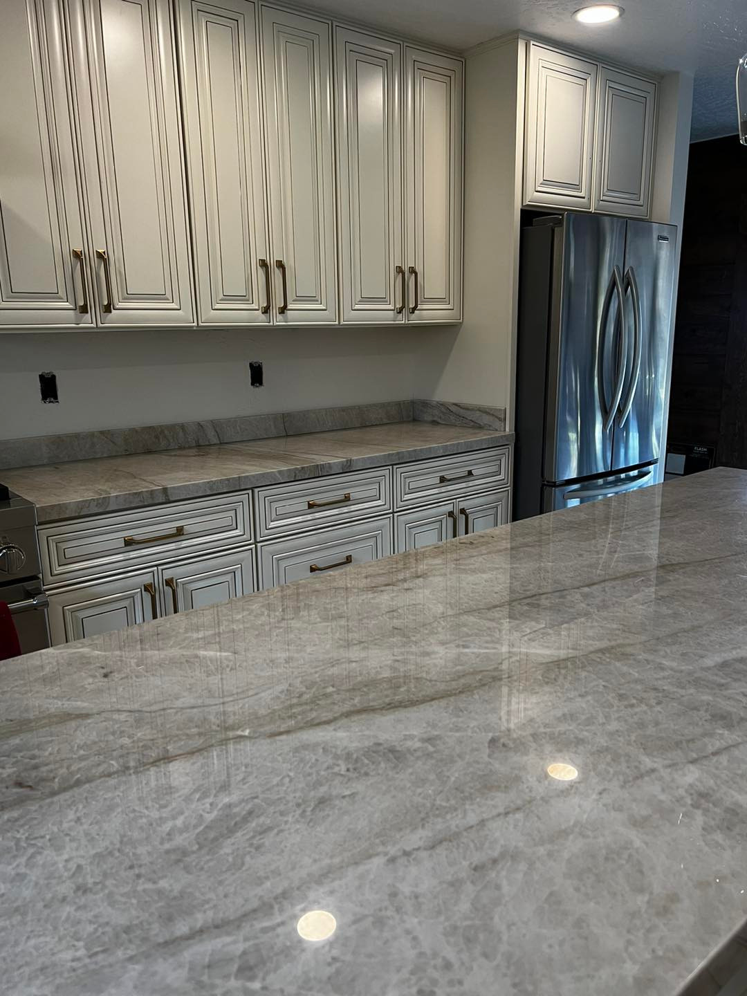 Kitchen Cabinets and Stainless Steel Refrigerator with Marble Countertop