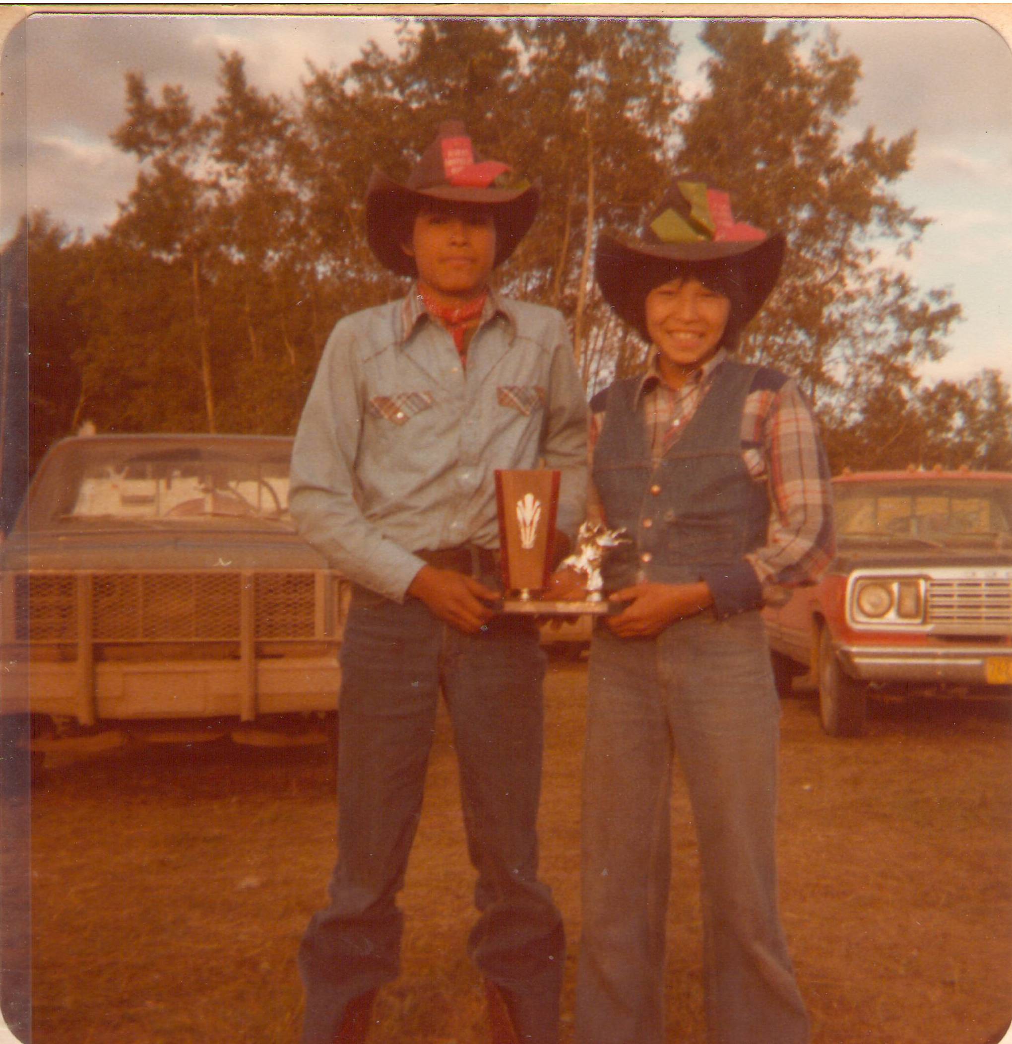 These two were at the Rocky Lane rodeo in 1979 - and based on the trophy they hold and the ribbons on their hats - must have had a successful time! If you know who they are please comment below!
2019.24.259 / Lizotte, Maria
These two have been identified as Curtis Chalifoux and Leon Deeza