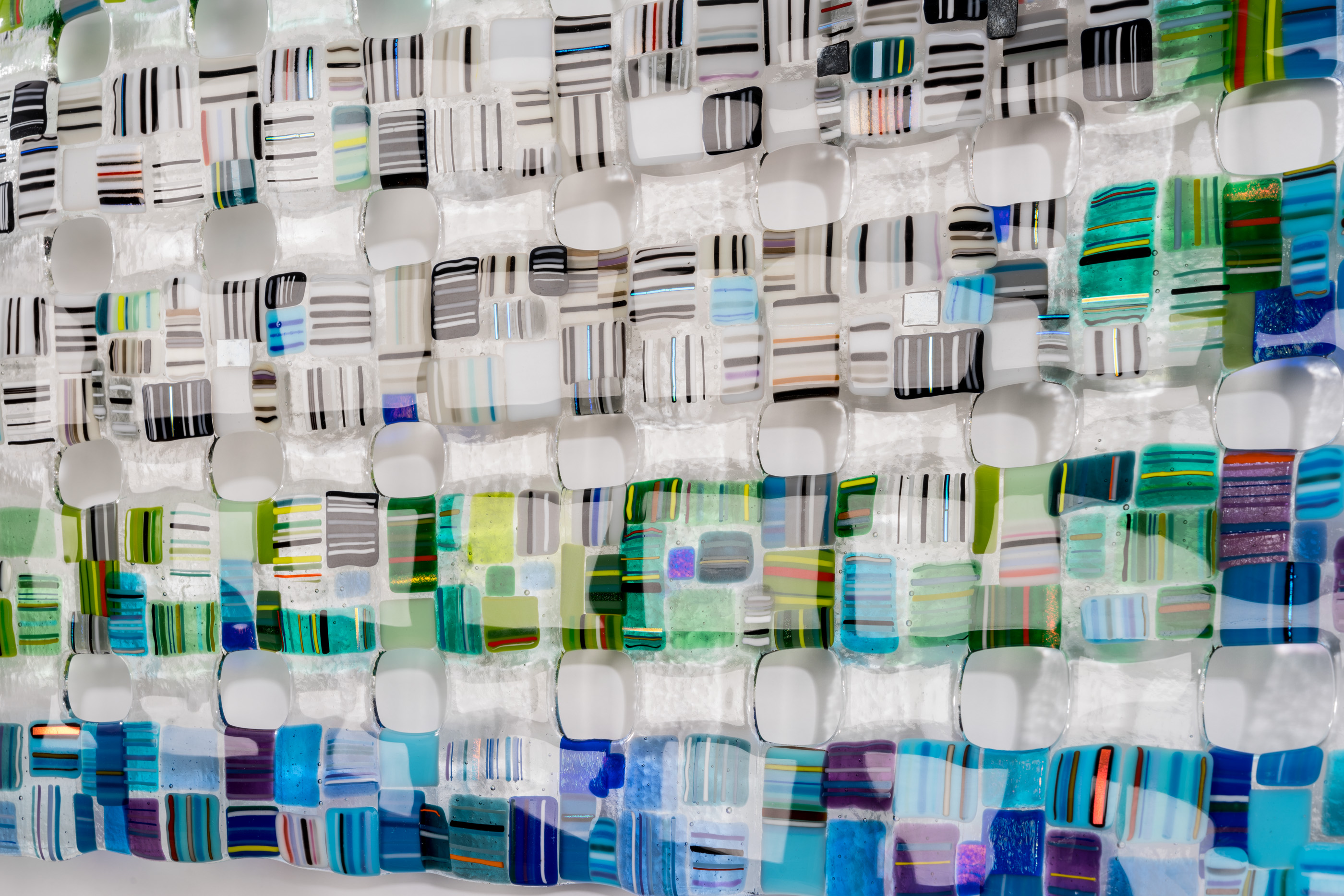 Modern interior room with glass walls, bookshelves, and colorful artwork.