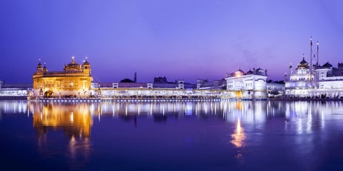 Golden Temple in Amritsar illuminated at twilight reflecting on the sacred pool