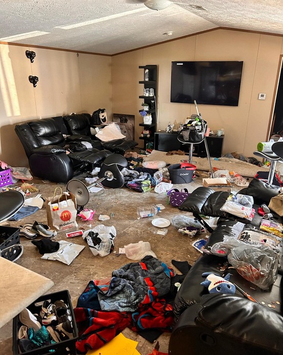 Living area in neglected property condition with clutter accumulation, disrupted organization, and environmental overwhelm requiring structured restoration