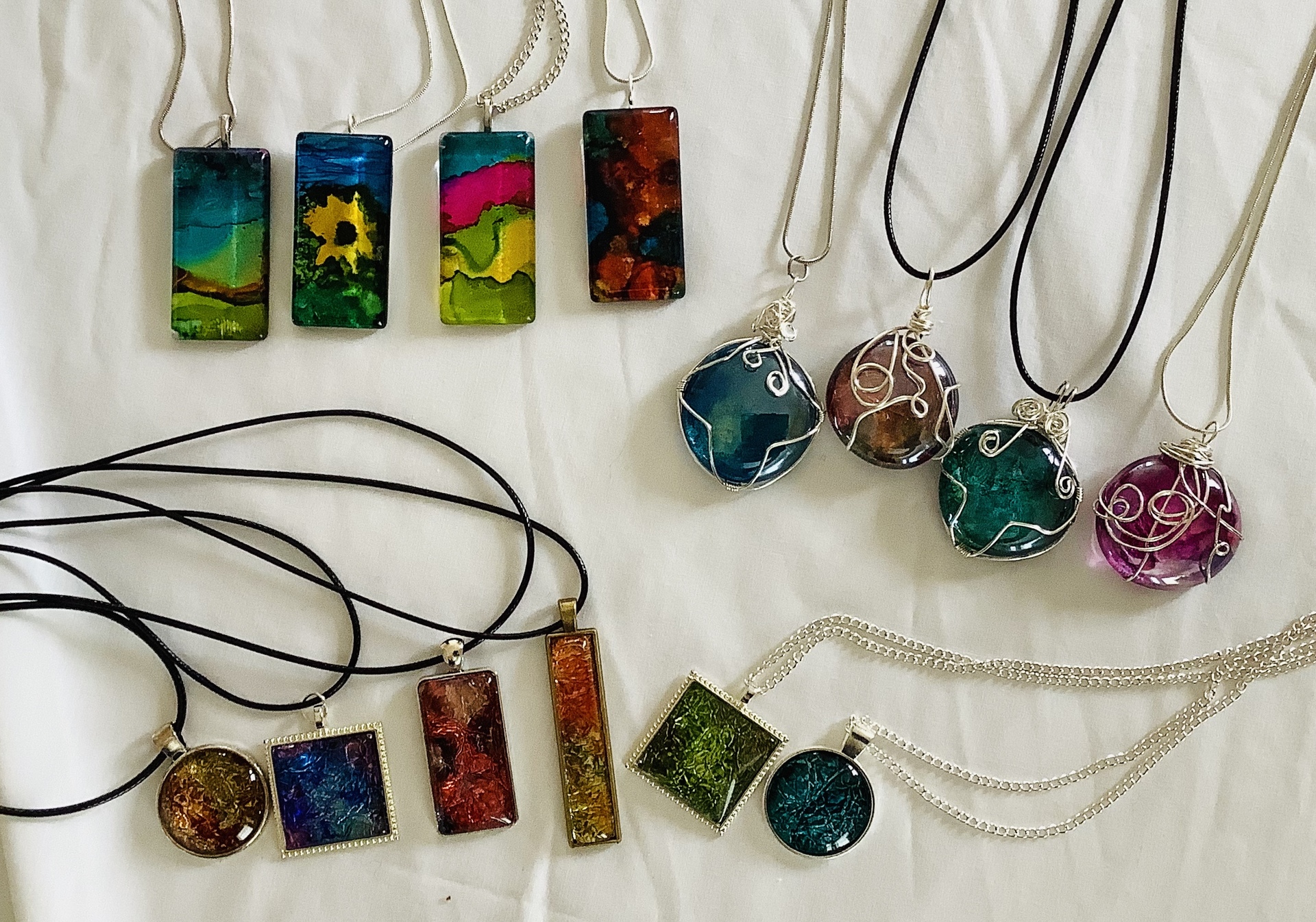 Alcohol Ink Pendants are individually hand painted in several styles and settings. Some are set in a tray while other are hand wired. Price $25.00 - $45.00