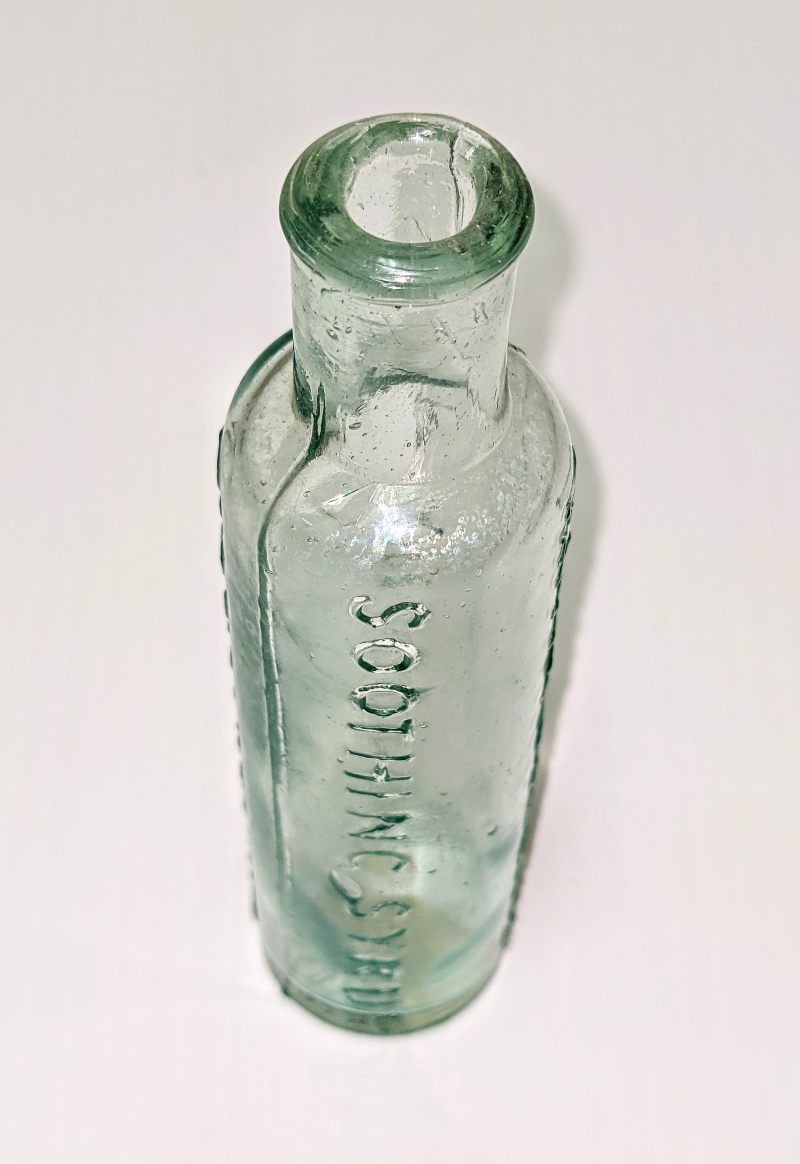 Mrs Winslow was a pediatric nurse who created this soothing syrup for fussy Babies in 1849. It was a patent medicine that claimed to relieve crying, teething, and dysentery - and was effective for all - as the concoction had enough morphine in a tsp (20 drops laudanum) to kill the average child (recommended no more then 3 drops laudanum). It was this high concentration of morphine that would put babies to sleep never to wake up again. Due to engaging marketing and lack of labelling, caregivers often would not make the connection that the syrup was the cause of death. In 1920 the food and Drug Act was created in Canada and required standard labeling of ingredients which alerted some caregivers to the high concentration of Morphine. Even so, the product was still widely sold until 1930s all while this "Baby Killer" continued to claim thousands of lives. Noting different characteristics of this bottle it was likely produced between 1865 and 1875 - making it over 145 yrs old!
19/07/2021
2017.22.171 / Creighton Harold + Evelyn