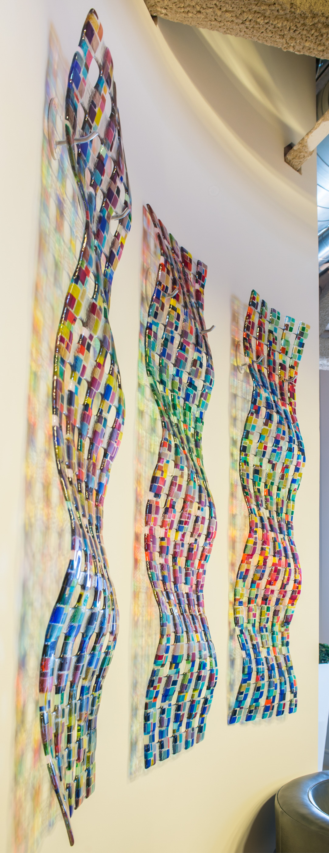 Modern, spacious lobby interior with tall windows, colorful panels, green plants, and stylish seating.