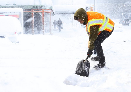 Snow Shoveling Service by Worker in Safety Vest
