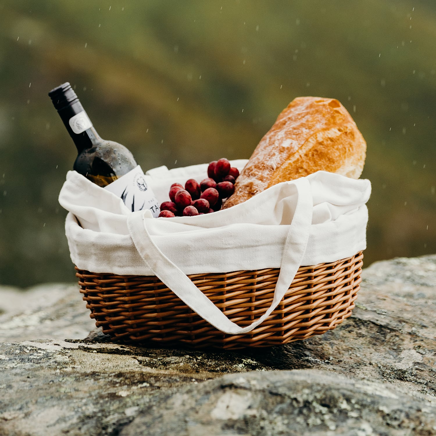 Two chefs in orange uniforms working in a modern kitchen with breads and cooking equipment in foreground.