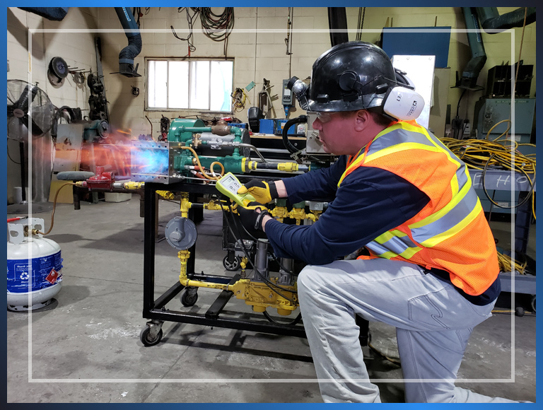A man wearing a safety vest and a hard hat, working on equipment